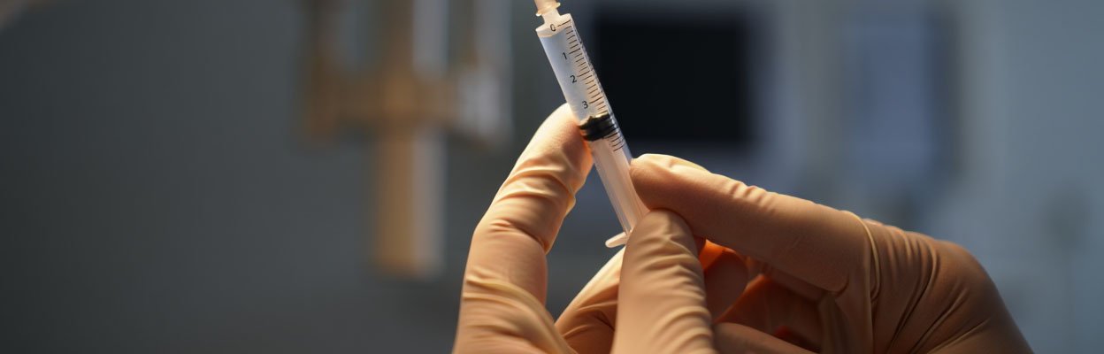 Руки держат шприц